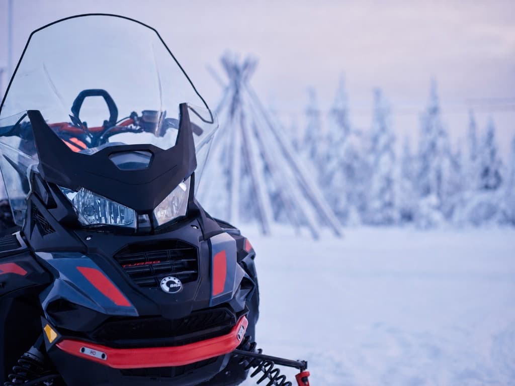 Snowmobile in a snowy forest clearing in Lapland